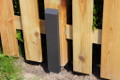 H-Anker-Kappe antrazit Beispielbild an einem Holzpfosten zwischen Staketenzäunen